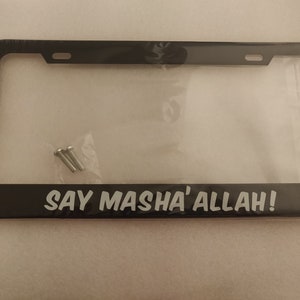 Puede incluir: Marco de matrícula negro con el texto blanco "SAY MASHA'ALLAH!". El marco es rectangular con esquinas redondeadas e incluye tornillos de montaje.