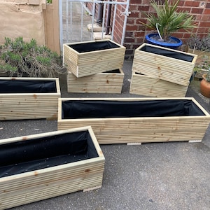 Handgemachte Pflanzgefäße. Ein kleiner Blumenkasten aus Holz für die Terrasse. Garten diy Trog Holz Outdoor Planter -Pflanzentopf