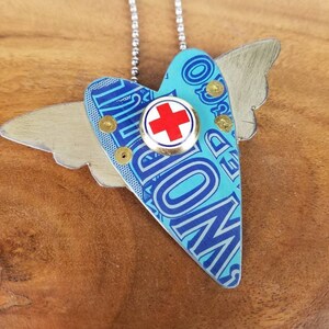 Upcycled Heart with Wings Pendant Necklace Made From a Vintage Tobacco Tin and a Red Cross Pin, can be worn as a necklace or brooch