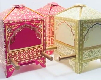 May include: Two decorative boxes in the shape of a palanquin, a traditional Indian mode of transport. The box on the left is red with gold accents, while the box on the right is cream with gold accents.
