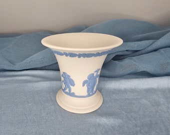 May include: A white ceramic vase with a blue and white floral design. The vase has a wide mouth and a narrow base.