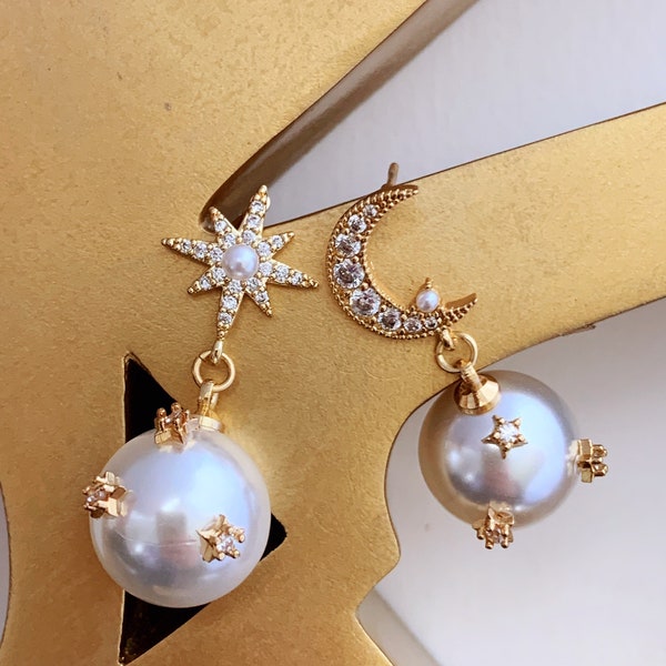 Boucles d'oreilles pendantes asymétriques en fausses perles : clous d'étoiles et de lune en strass