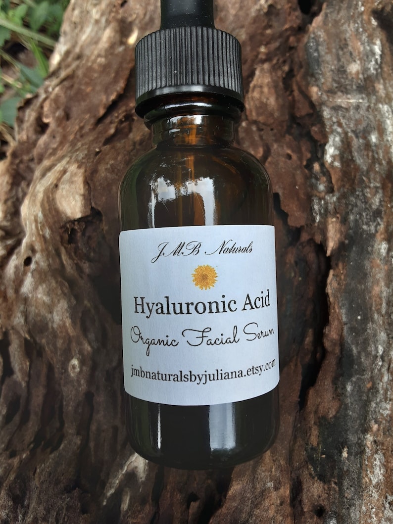 May include: A brown glass bottle with a black dropper top and a white label that reads "J.M.B. Naturals Hyaluronic Acid Organic Facial Serum jmbnaturalsbyjuliana.etsy.com".