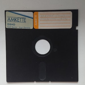 May include: A black 3.5 inch floppy disk labeled "AMKETTE DSHD Soft Sector High Density" with a white label on the top that reads "LEXICON (5.25) 2934V564386 13572".