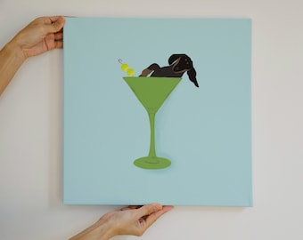 May include: A black and brown dachshund dog is lying in a green martini glass with a green olive garnish. The glass is on a light blue background.