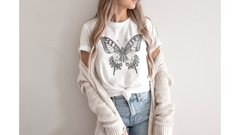 May include: A white t-shirt with a black and white butterfly graphic print.