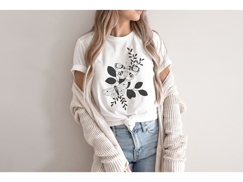 May include: White t-shirt with a black and white graphic of two butterflies on a branch with leaves.