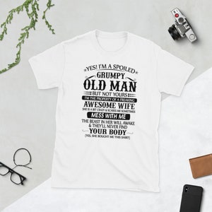 Könnte beinhalten: Weißes T-Shirt mit schwarzem Text: "YES! I'M A SPOILED GRUMPY OLD MAN BUT NOT YOURS I'M THE PROPERTY OF A FREAKING AWESOME WIFE MESS WITH ME YOUR BODY". Eine humorvolle Geschenkidee.