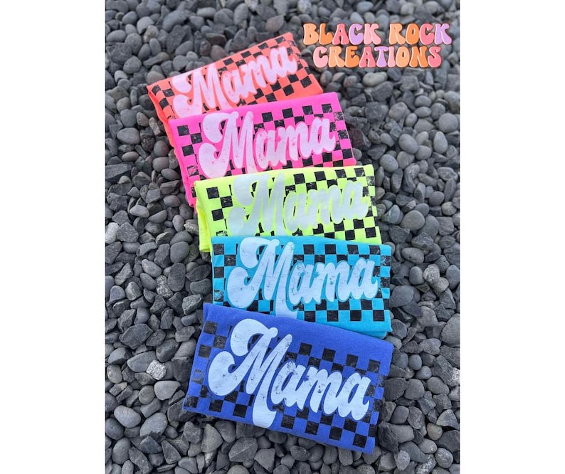 May include: Five colorful t-shirts with a checkered pattern and the word "Mama" printed in white on each shirt.