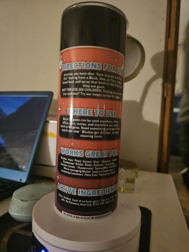 Puede incluir: Una botella de spray negra y roja con texto que dice "DIRECTIONS FOR USE" y "WORKS GREAT FOR". La botella es cil&iacute;ndrica y se asienta sobre una base blanca. El texto es en blanco y rojo.