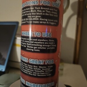 Puede incluir: Una botella de spray cil&iacute;ndrica con una etiqueta roja y blanca. La etiqueta presenta texto como "DIRECTIONS FOR USE" y "WORKS GREAT FOR". La botella est&aacute; sobre una superficie blanca.