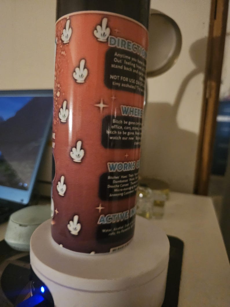 Puede incluir: Un recipiente cil&iacute;ndrico con fondo rojo y gestos de manos blancos. El recipiente tiene texto que dice "DIRECTIO", "NOT FOR USE ON", "WHERE", "WORKS" y "ACTIVE IN".