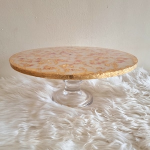 White and gold leaf cake stand with dried petals and glass base