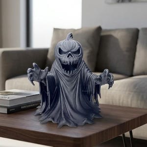 May include: A dark gray Halloween decoration in the shape of a ghost with a pumpkin head. The ghost has outstretched arms and a menacing grin. The figure is on a wooden table.
