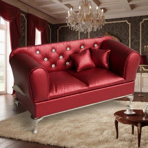 Puede incluir: Un sofá rojo de dos plazas con respaldo acolchado y detalles de cristal. El sofá tiene patas plateadas y dos cojines rojos a juego. El sofá está colocado sobre una alfombra color crema.