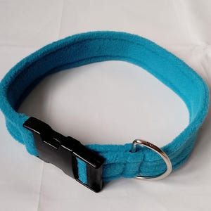 Pu&ograve; includere: Un collare per cani blu turchese con una fibbia in plastica nera e un anello a D in metallo argentato.