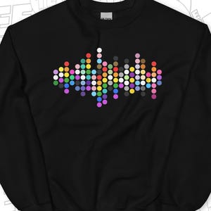 Puede incluir: Sudadera negra con un diseño pixelado de colores que se asemeja a una onda sonora.