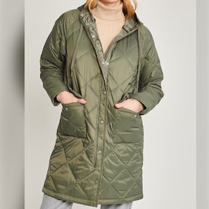 May include: A long-sleeved quilted jacket with a hood. The jacket is a dark olive green color and has a diamond quilted pattern. The jacket has a zipper closure and button accents.