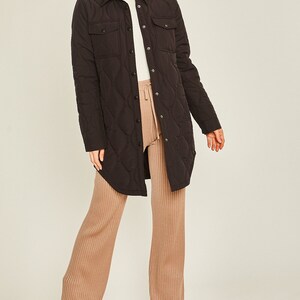 May include: A black quilted long-sleeve shirt jacket with a button-up front and two flap pockets.