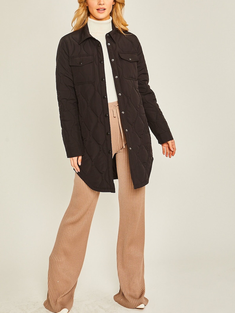May include: A black quilted long-sleeve shirt jacket with a button-up front and two flap pockets.