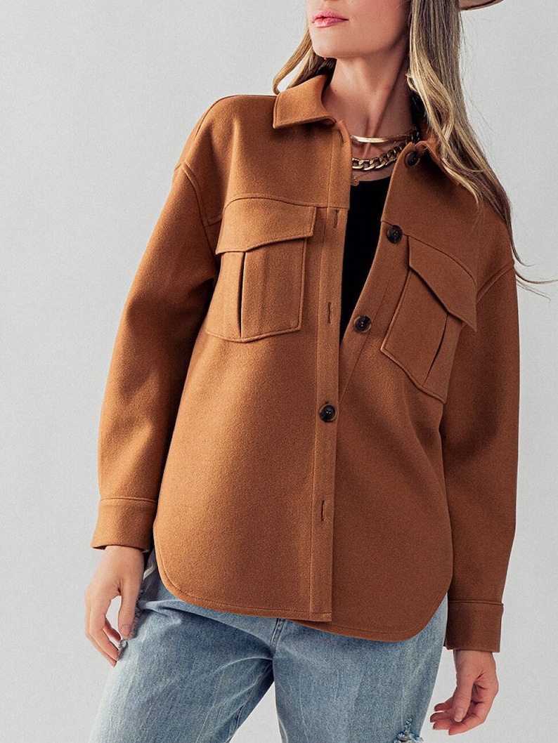 May include: A brown, long-sleeved shirt with a button-up front and two large pockets. The shirt has a relaxed fit and is made of a soft, comfortable fabric.