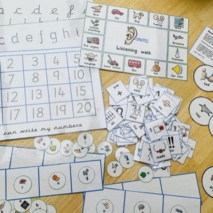 Puede incluir: Un conjunto de materiales educativos para niños, que incluye hojas de trabajo de trazado de alfabeto y números, tarjetas con imágenes y palabras, y una actividad de paseo auditivo. Los materiales están impresos en papel blanco y presentan ilustraciones coloridas.