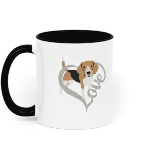 May include: White ceramic mug with a black interior and handle. The mug features a brown and white beagle dog illustration inside a gray heart with the word "Love" written inside the heart.