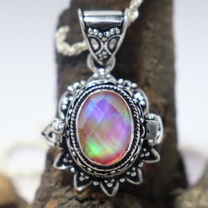 May include: A silver pendant with a large iridescent gemstone set in an ornate silver frame. The pendant is attached to a silver chain.
