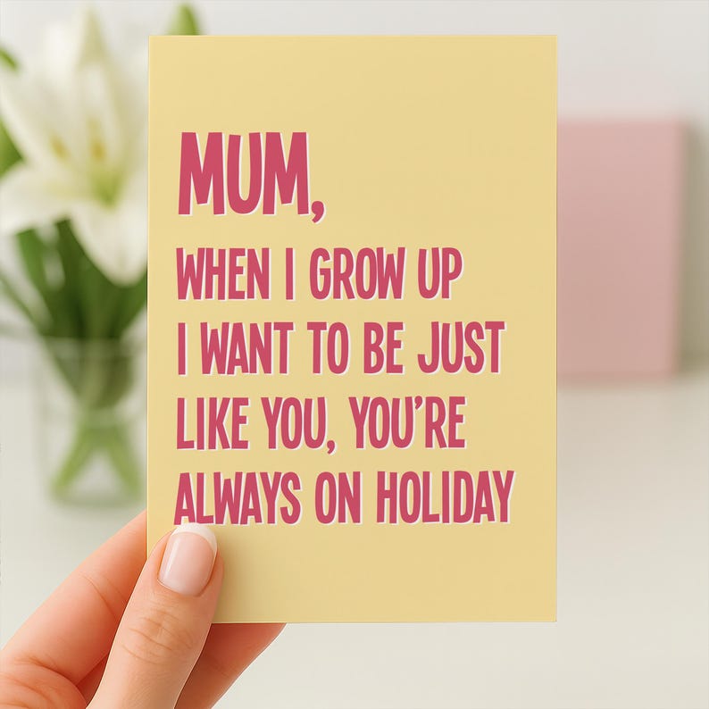 May include: A yellow greeting card with the text "MUM, WHEN I GROW UP I WANT TO BE JUST LIKE YOU, YOU'RE ALWAYS ON HOLIDAY" in pink. The card is held by a person's hand.