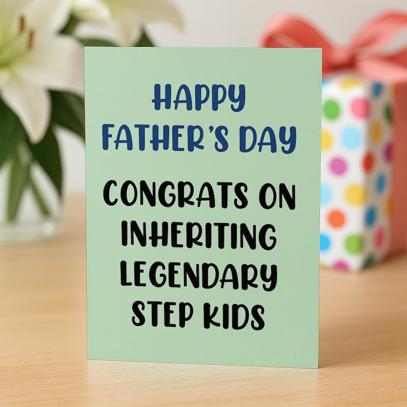 Op de afbeelding: Een lichtgroene Vaderdagkaart met de tekst "HAPPY FATHER'S DAY CONGRATS ON INHERITING LEGENDARY STEP KIDS" in blauwe en zwarte tekst. Een cadeauverpakking met een rode strik staat op de achtergrond.