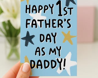 May include: A light blue Father's Day card with the text "Happy 1st Father's Day as my Daddy!" in black. The card is decorated with white, gold, and navy blue star illustrations.
