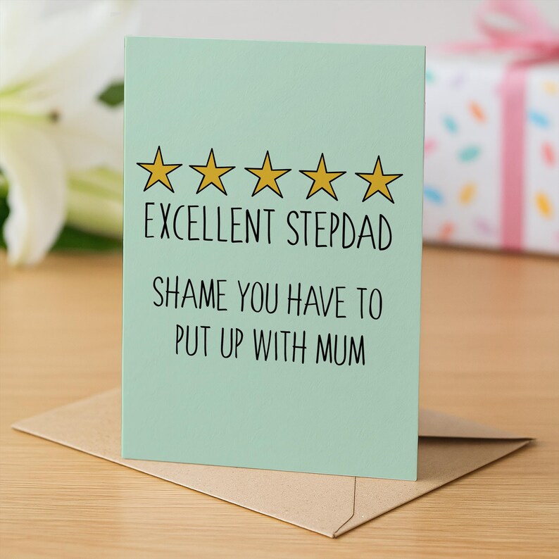 May include: A light green greeting card with the text "EXCELLENT STEPDAD SHAME YOU HAVE TO PUT UP WITH MUM" and five gold stars. The card is on a brown envelope.
