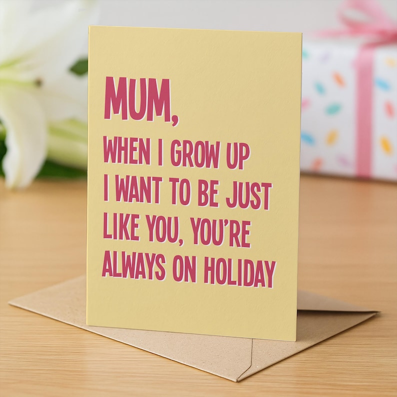 May include: A greeting card with a light yellow background and a brown envelope. The card has the text "MUM, WHEN I GROW UP I WANT TO BE JUST LIKE YOU, YOU'RE ALWAYS ON HOLIDAY" in pink letters.