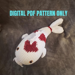 Puede incluir: Un pez koi de ganchillo blanco y rojo con ojos marrones y un bigote blanco. El pez tiene manchas rojas en la espalda y la cola. El texto en la imagen dice "DIGITAL PDF PATTERN ONLY".