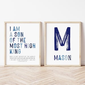 Op de afbeelding: Twee ingelijste prints met inspirerende citaten en een naam. Eén print toont "I AM A SON OF THE MOST HIGH KING" in blauwe tekst. De andere print heeft een grote blauwe "M" en de naam "MASON" eronder.