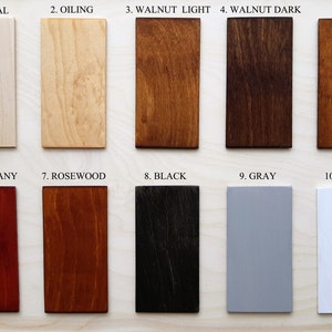 May include: A collection of ten rectangular wood samples showcasing various finishes. The samples include "Natural," "Oiling," "Walnut Light," "Walnut Dark," "Oak," "Mahogany," "Rosewood," "Black," "Gray," and "White," each labeled with its respective name.