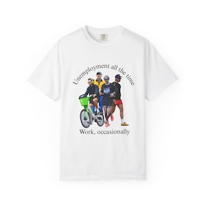 Puede incluir: Camiseta blanca con un gráfico de cuatro personas, una de ellas montada en una bicicleta verde lima. El texto "Unemployment all the time" se arquea sobre las figuras, con "Work, occasionally" debajo. La camiseta tiene cuello redondo.