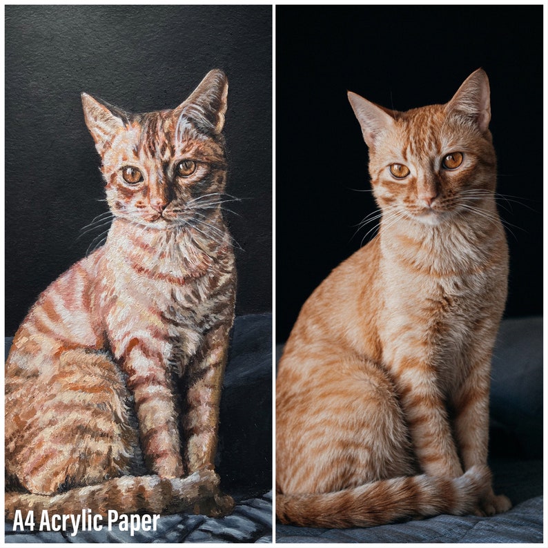 May include: A side-by-side comparison of a painting of a tabby cat and a photograph of a tabby cat. The painting is on A4 acrylic paper. Both cats are sitting with their front paws tucked under their bodies.