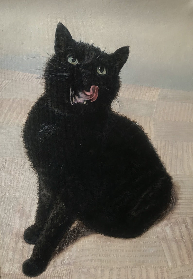 May include: A black cat with green eyes sits on a white and brown patterned surface. The cat has its mouth open and its tongue sticking out.