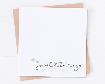 May include: A blank white card with a brown envelope. The card has the text "just to say" with three small hearts.