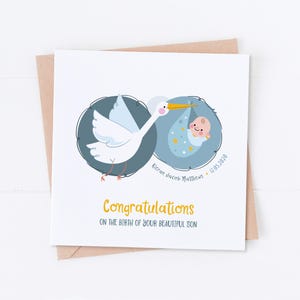 May include: A white stork carrying a baby in a blue and white blanket with stars. The card says "Congratulations on the birth of your beautiful son" and "Kieran Jacob Matthews - 12.05.2020".