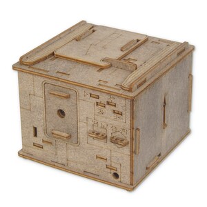 May include: A wooden box with a hinged lid and a small hole in the front. The box has a number of small slots and markings on the front and sides. The box is made of light brown wood and has a natural finish.