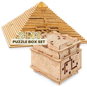Könnte beinhalten: Ein 2-in-1-Puzzlebox-Set aus Holz. Das Set enthält eine pyramidenförmige Puzzlebox und eine würfelförmige Puzzlebox. Die Pyramidenbox ist aus hellbraunem Holz gefertigt und hat ein geschichtetes Design. Die Würfelbox ist aus dunkelbraunem Holz gefertigt und hat ein komplexes Design mit einem Schiebemechanismus.