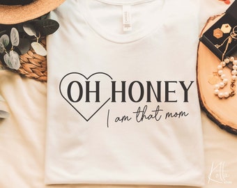 Puede incluir: Camiseta blanca con un corazón negro y el texto "Oh Honey I am that mom".