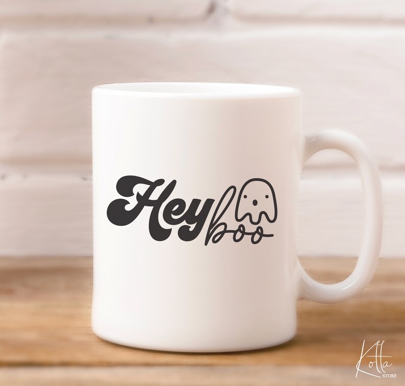 May include: White ceramic mug with a black design that says "Hey Boo" with a ghost illustration.