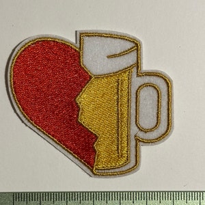 Peut inclure: Patch brodé thermocollant représentant un cœur rouge avec un morceau cassé, remplacé par une chope de bière dorée avec de la mousse blanche.