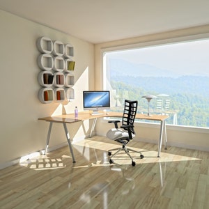 May include: A white desk with a black computer monitor and a black office chair sits in a room with a large window overlooking a green forest. The desk has a white shelf unit on the wall behind it.