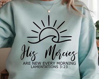 May include: Light blue sweatshirt with a black graphic of a sun rising over a wave. The text "His Mercies Are New Every Morning Lamentations 3:23" is printed below the graphic.