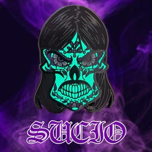 May include: A black enamel pin featuring a stylized sugar skull design with teal and purple accents. The skull has long black hair and floral details. The word "SUICID" is written in a decorative font at the bottom.