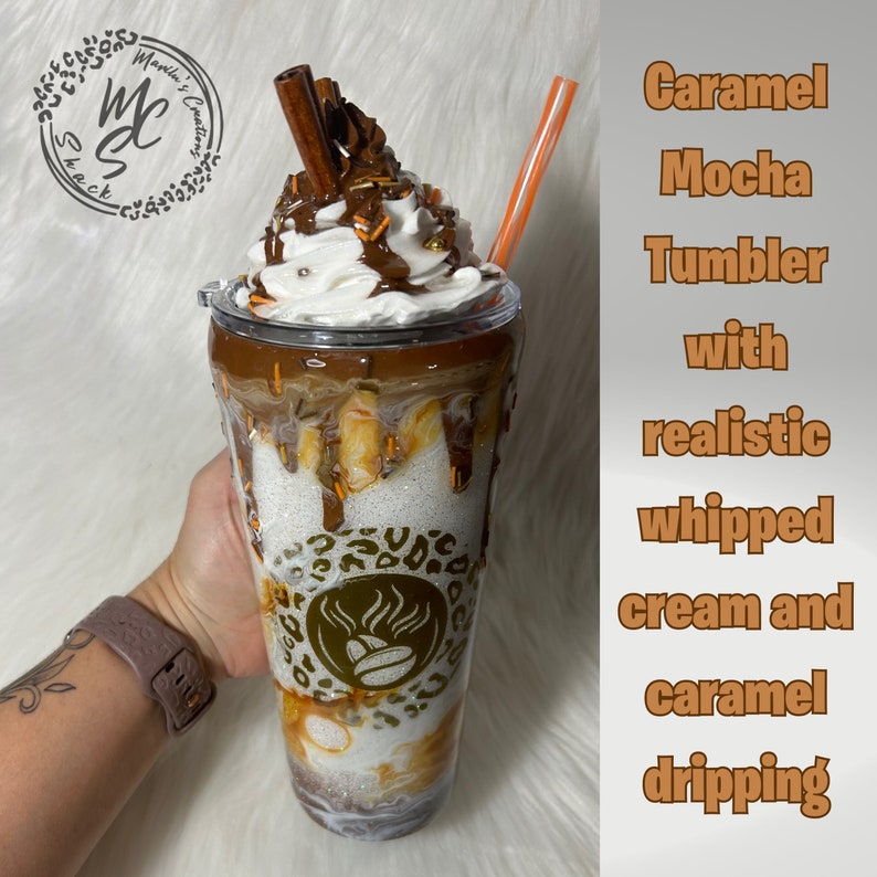 May include: Caramel Mocha Tumbler with realistic whipped cream and caramel dripping. The tumbler has a brown and gold leopard print design with a coffee cup logo.